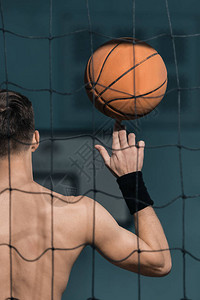 男子用手指拿着篮球的背影图片