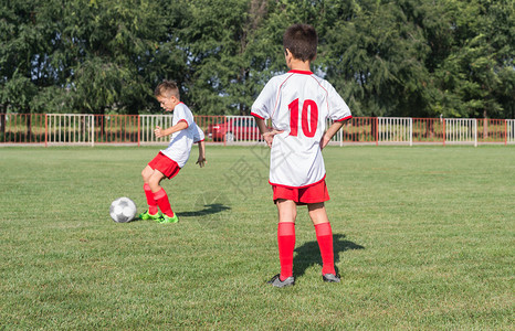 男孩在球门前踢球图片