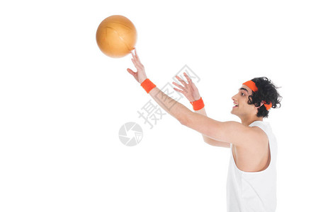 微笑的瘦运动员扔球在白色背景图片