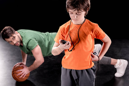 集中的男孩手表控制时间男子在黑球训练时图片