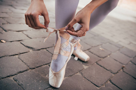 年轻芭蕾舞演员在街上系足尖鞋的短片图片
