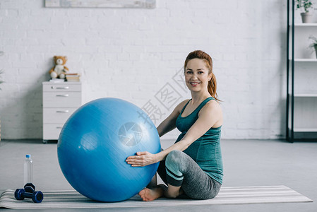坐在瑜伽垫子上在有健身球图片