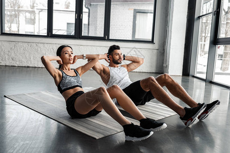 在健身房瑜伽垫子上做腹部锻炼的图片