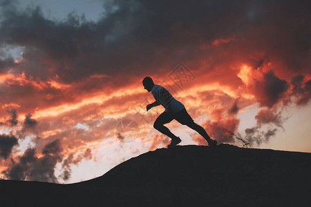一个运动男子在山下奔向山丘图片