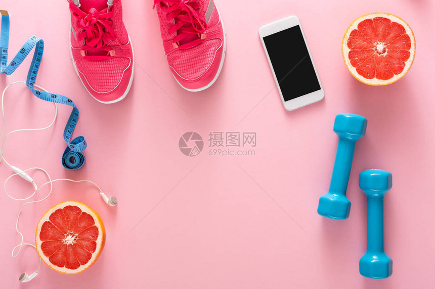 健身背景运动器材复制空间粉色背景中的哑铃葡萄柚运动鞋卷尺和图片