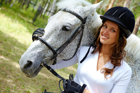 在骑着纯种马的帽子和看着相机的镜头中女背景图片