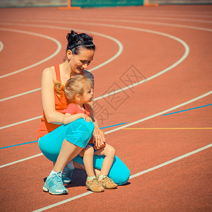 母亲和小女儿在体育场周围跑步和运动训练孩子在体图片