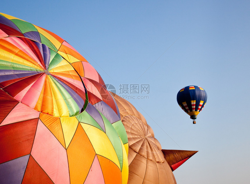 单个热气球飞向天空在另外两个高空图片