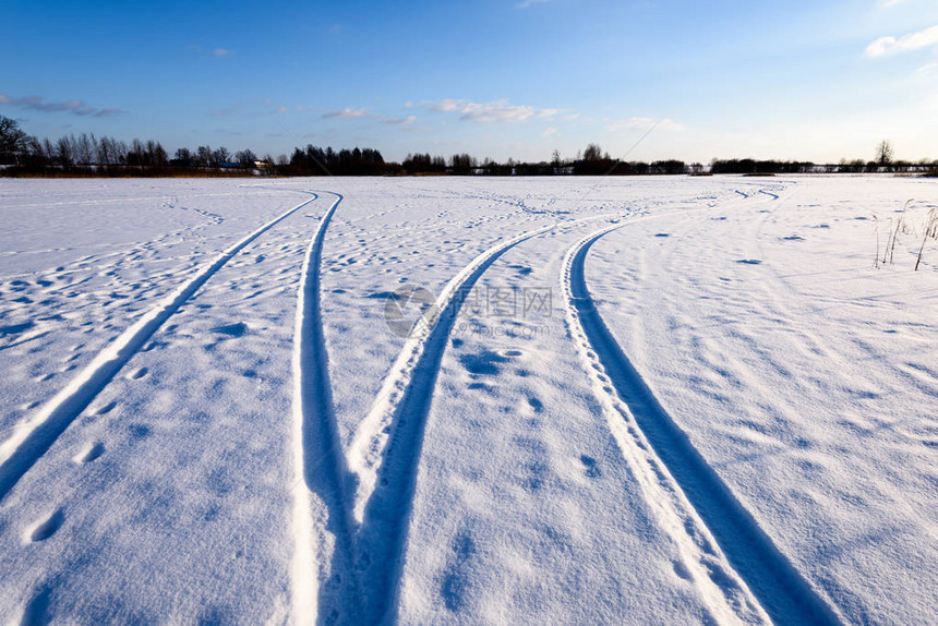 深雪中覆盖的冬季雪路车胎轨迹向图片