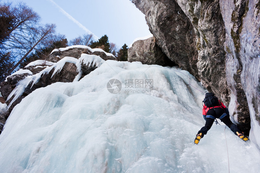陡峭冰瀑上的攀冰者水平的西阿尔卑斯山图片