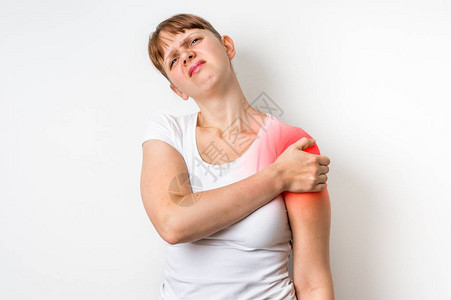 怀着肩部疼痛的女人抱着她的手臂身背景图片