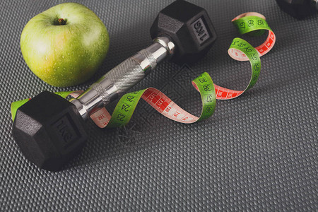 健身设备健康的生活方式哑铃苹果和灰色背图片