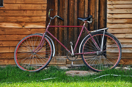 木屋附近的老式红色自行车图片