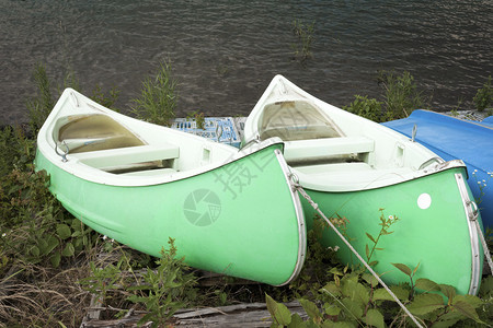 湖岸上的两艘绿色独木舟背景图片