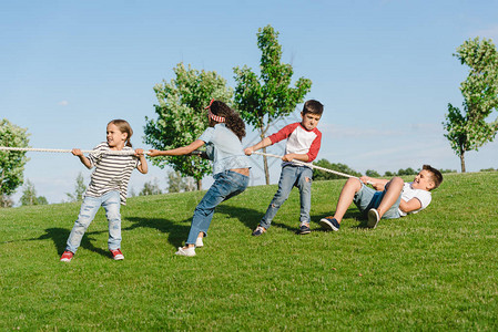 多民族儿童拉绳子在公园图片
