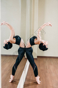 年轻运动女仰着镜子反射在舞蹈演播图片