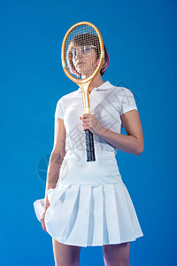网球运动员用蓝色隔离的网球拍遮住脸图片