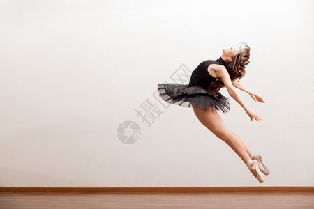 在跳跃期间的华美的芭蕾舞女演员图片