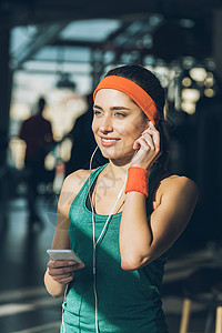 在健身房使用智能手机和耳机的图片