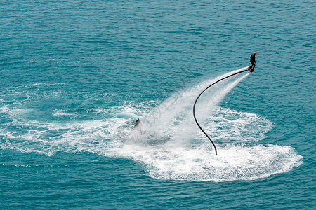 在海滨度假胜地的海蓝宝石水域进行飞板训练背景图片