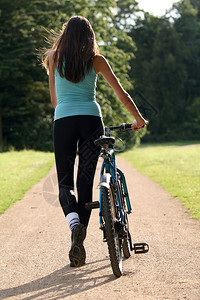 在路上骑自行车的健身女人背景图片