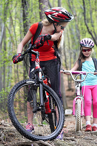 自行车骑自行车的家庭快乐的母女戴着头盔骑自行车进图片