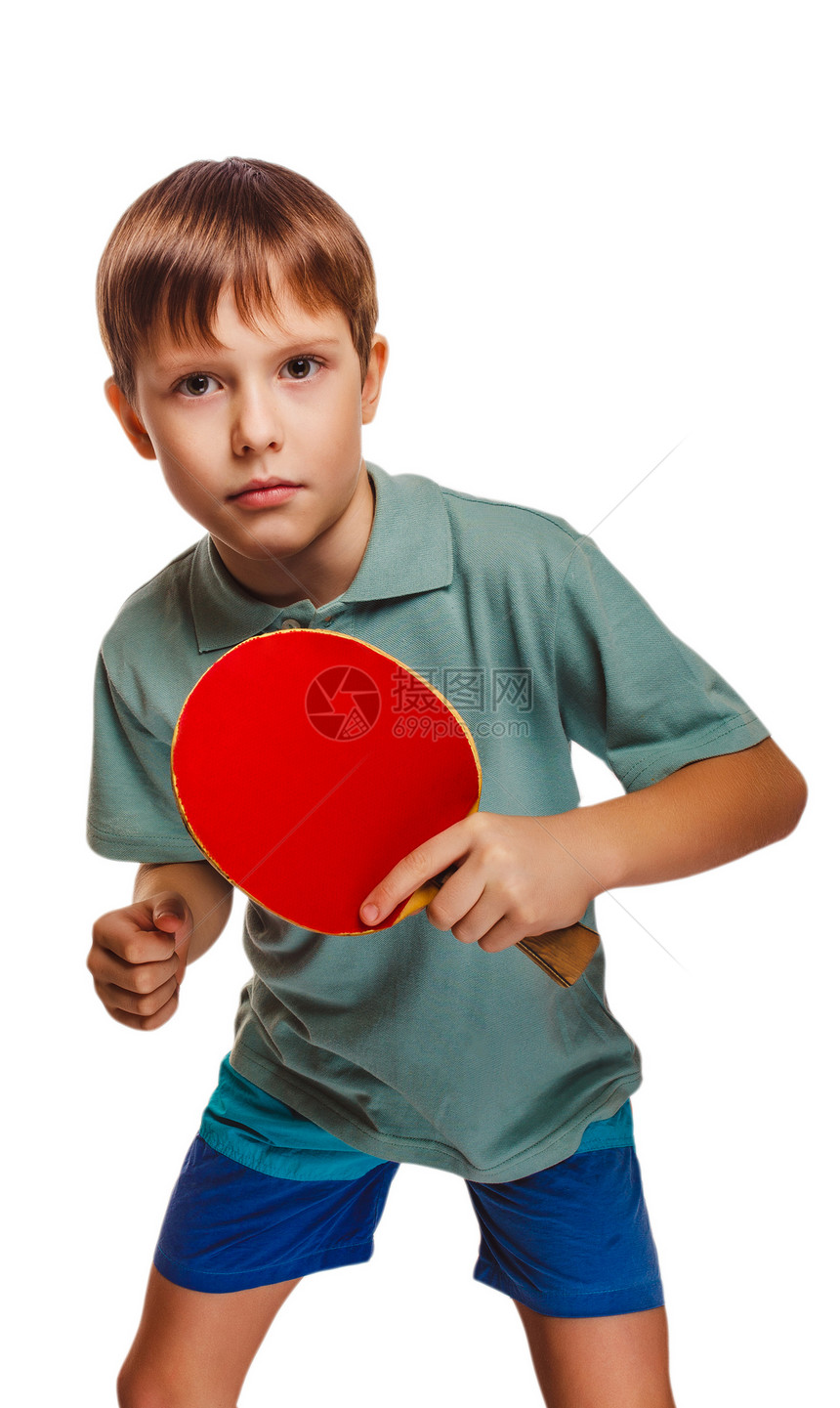 金发的打乒乓球的男孩打桌网球背手以白种背景孤图片