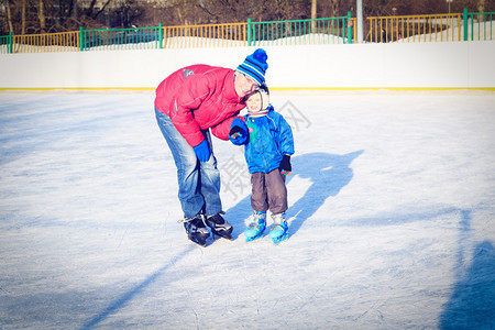 小男孩和家长滑冰图片