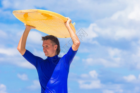 健壮的青年冲浪男子跑在海图片