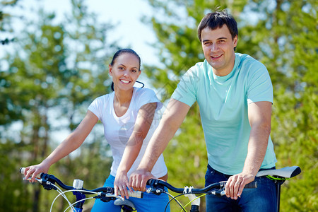 一对骑自行车的年轻夫妇背景图片