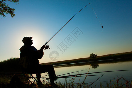 在湖边钓鱼的年轻人图片