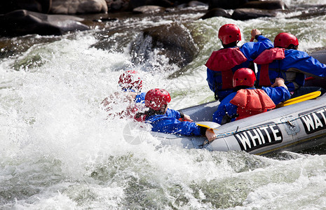 一群冒险者在快速移动的河流中的白水中背景图片