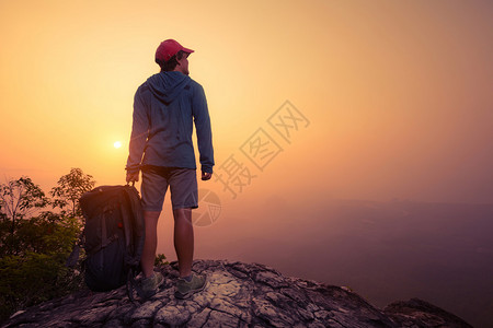 徒步旅行者背着包站在山顶图片