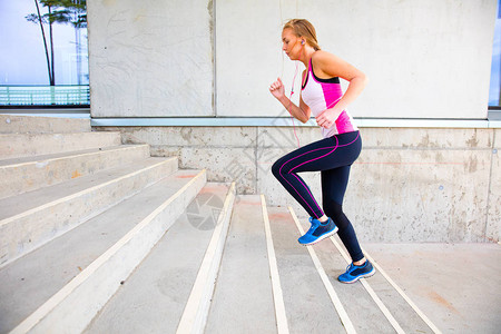 健身女人在建筑的台阶上奔跑女赛跑运动员上背景图片