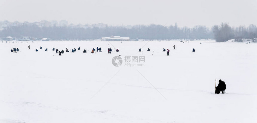 冬季钓鱼远景的观渔夫图片