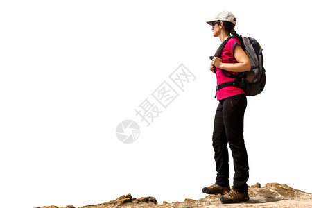 带着背包和靴子的年轻女徒步旅行者站在岩石上图片