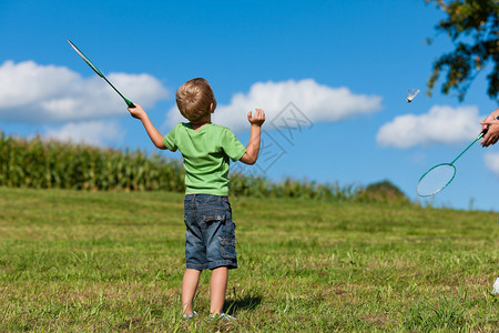 家庭小男孩玩羽毛球在夏日图片