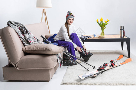 在家坐在沙发上时穿着滑雪靴的年图片