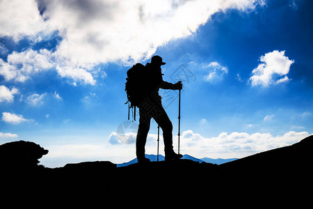 背着包在山上的徒步旅行者剪影图片