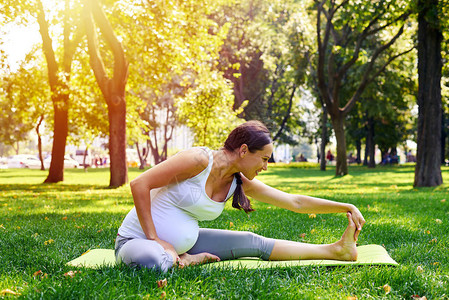 孕妇在公园里做放松瑜伽锻炼的侧视图图片
