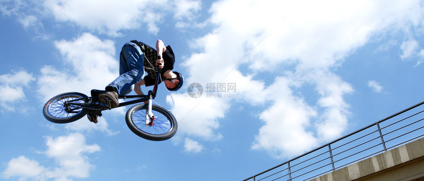 在跳跃期间骑自行车的杂技演员图片