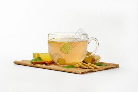 一杯姜茶加柠檬新鲜姜树根和棕色地图片