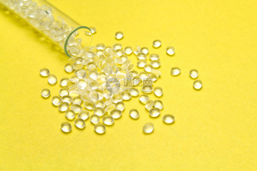黄色背景的透明聚乙烯颗粒HDPE塑料颗粒可塑原材料图片