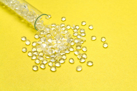 黄色背景的透明聚乙烯颗粒HDPE塑料颗粒可塑原材料图片