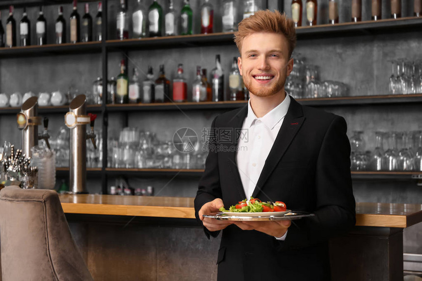 餐厅里有菜的年轻男服务员图片