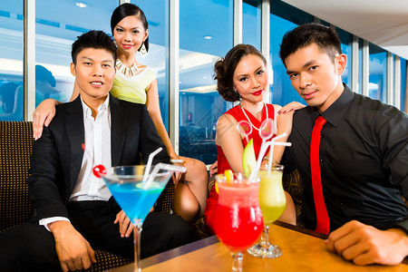 年轻英俊的亚洲华人在豪华别致的酒廊喝鸡尾酒喝鸡尾酒图片