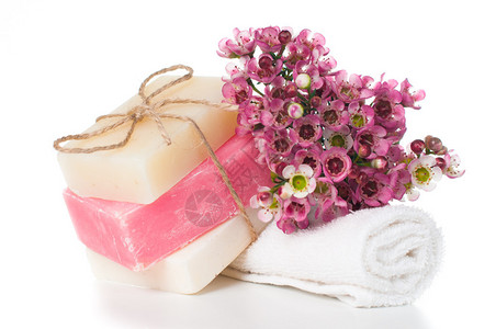 用于水疗毛巾白色和粉红色手工肥皂和白色背景上的粉红色樱花的产品图片