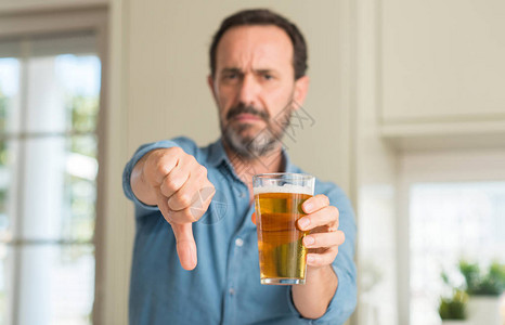 中年男子喝啤酒时脸发愤怒图片