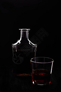 杯威士忌与黑色桌子上的瓶子图片