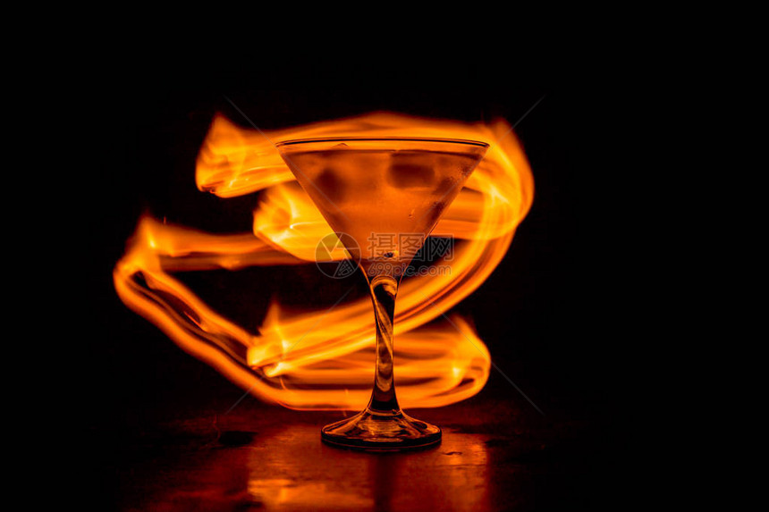 著名鸡尾酒马丁尼在深灰雾背景下燃烧的烈火中有选择图片